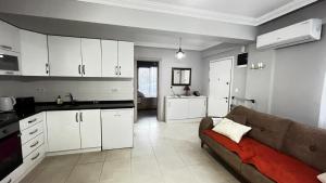 een woonkamer met een bank en een keuken bij Elit Yaşam Site 1-Bedroom flat with pool in Fethiye