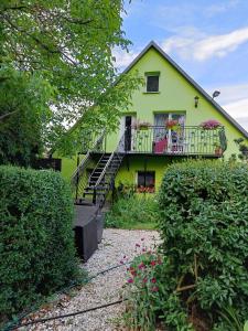 una casa gialla con balcone fiorito di Farcik Apartament a Nowa Wieś