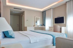 a hotel room with a bed and a television at Meydani Otel in Gokceada Town