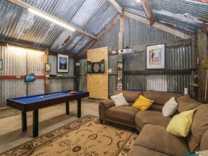 un soggiorno con divano e tavolo da ping pong di Mill House Cottage a Pwllheli