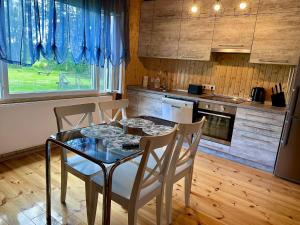 uma cozinha com uma mesa e cadeiras numa cozinha em East side in Tervola with sauna and free parking em Tervola