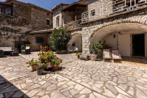 a stone courtyard with potted plants in a building at chambres d'hôtes "les Monteils" in Grospierres