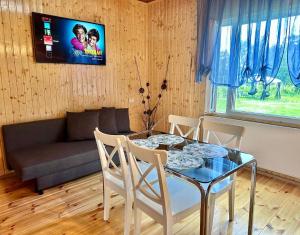 uma sala de estar com uma mesa de vidro e um sofá em East side in Tervola with sauna and free parking em Tervola