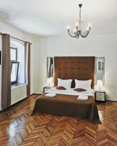 a bedroom with a large bed and a chandelier at Classic Home in Sibiu