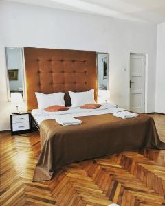 a bedroom with a large bed with a large headboard at Classic Home in Sibiu