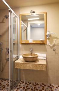 a bathroom with a sink and a mirror and a shower at Meydani Otel in Gokceada Town +21 photos