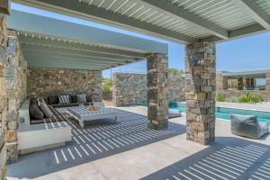 an outdoor patio with a couch and a table at Villa Xifara - Seafront in Santa Maria