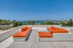 two orange benches sitting on top of a patio at Villa Xifara - Seafront in Santa Maria