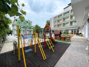 un parco giochi in un cortile con un edificio di Hotel Onyx a Kiten