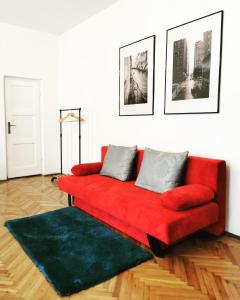 a red couch with two pillows on it in a living room at Classic Home in Sibiu