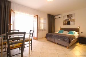 a bedroom with a bed and a table and chairs at Apartment Rajka 2277 in Premantura