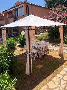 tenda bianca con tavolo e sedie sotto di Casa 3 pesciolini a Portoferraio