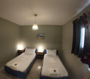 um quarto com duas camas e um candeeiro em Mavretas Apartments 4 em Argasi