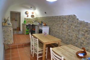cocina y comedor con mesa y sillas en Guesthouse Bosa di Giuseppe, en Bosa