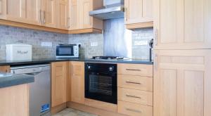 a kitchen with wooden cabinets and a stove top oven at Mill Cottage in Sawrey