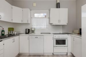 - une cuisine blanche avec des armoires et des appareils blancs dans l'établissement Holiday home in Onsala near the beach, à Onsala