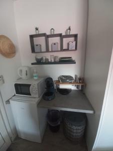 a small kitchen with a microwave on a counter at Lauraym 1 in Baie-Mahault