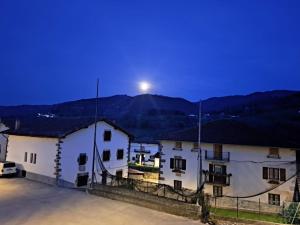 a view of two white buildings at night at Posada de Oitz in Oiz