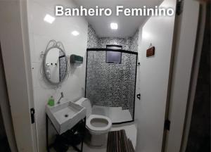 La salle de bains est pourvue d'un lavabo, de toilettes et d'un miroir. dans l'établissement Pousada CNU, à Rio de Janeiro