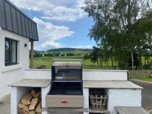 a barbecue grill on the side of a building at Luxury Lodge with Hot Tub at Lindores in Newburgh