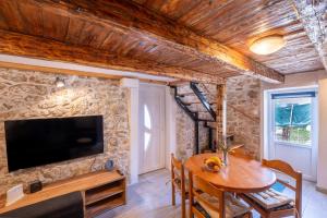 comedor con mesa de madera y TV en Kuća za odmor Nikola en Zadar