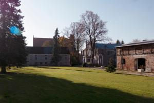 un gran patio con un edificio y un campo de césped en Gorzelnia w Żarnowcu en Żarnowiec