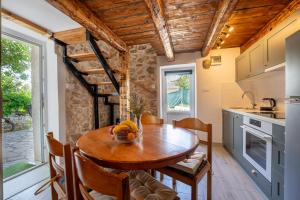 uma cozinha e sala de jantar com uma mesa de madeira e cadeiras em Kuća za odmor Nikola em Zadar