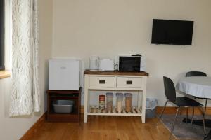 um quarto com uma mesa com uma televisão e uma cama em Narrow water house em Dundalk