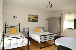 um quarto com 2 camas e almofadas amarelas em Narrow water house em Dundalk