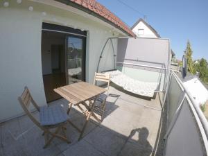 a wooden table and a chair on a balcony at HappyBNB Apartment mit sonniger Terrasse in Löchgau