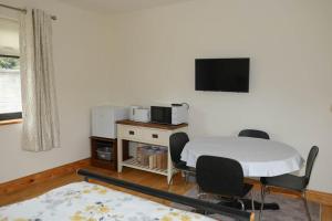 een kamer met een tafel en stoelen en een tv aan de muur bij Narrow water house in Dundalk