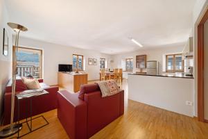 sala de estar con sofá rojo y cocina en Appartement Wielander B West en Laces