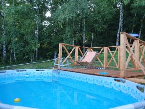 a wooden bridge over a swimming pool with a deck and a chair at Księżycowa Dolina in Lądek-Zdrój