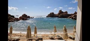 vista su una spiaggia con ombrelloni e sull'oceano di Sardinia Sea Vacation Villa a Costa Paradiso