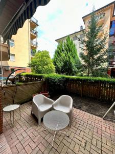 een patio met 2 stoelen, 2 tafels en een hek bij S3 Residences Ilka Studio Serviced Cozy Appartment in Boedapest
