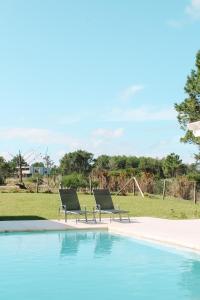 2 sillas están sentadas junto a una piscina en Casa de mar - José Ignacio, en José Ignacio