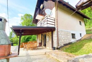 a patio of a house with chairs and a balcony at Plitvice RH Hostel Rooms in Jezerce