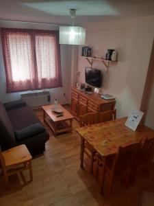 - un salon avec une table et un canapé dans l'établissement Apartamento Canfranc, à Canfranc-Estación
