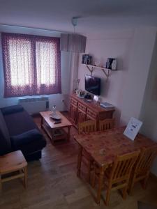 - un salon avec une table et un canapé dans l'établissement Apartamento Canfranc, à Canfranc-Estación