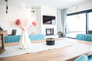 Una mesa de comedor con un jarrón de flores encima. en Villa Istra Relax Sapphire, en Rebići
