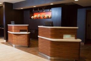 a lobby with two reception desks and a painting on the wall at Courtyard Burlington Williston in Burlington