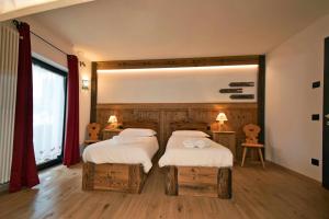 1 dormitorio con 2 camas y ventana grande en Cirmolo Val Comelico Comfortable e Spacious, en Padola