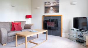 a living room with a couch and a fireplace at Mill Cottage in Sawrey