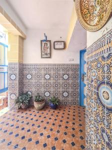 a room with tiles on the walls and a blue door at Riad MIYA in Essaouira