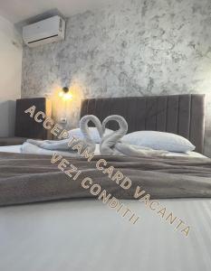 a bedroom with a bed with two wedding rings on it at Ama Boutique in Constanţa