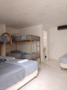 a bedroom with two bunk beds and a couch at Hostel Santa Marta el Rodadero in Santa Marta