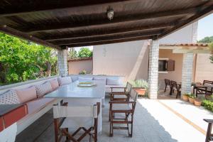 un patio con sofá, mesa y sillas en Alex & Billy House by Travel Pro Services - Nea Flogita Halkidiki, en Zográfos