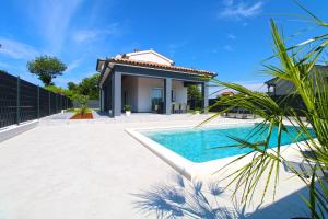 een villa met een zwembad en een huis bij House Sanja 2278 in Pula