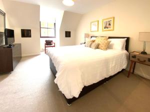 a bedroom with a large white bed and a television at Lochindaal - Beautiful, Spacious 4 Bedroom House in Kintyre in Whitehouse
