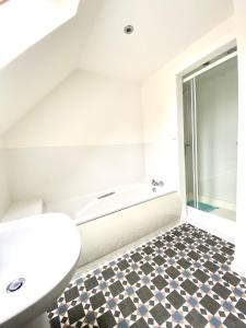 a bathroom with a bath tub and a toilet at Lochindaal - Beautiful, Spacious 4 Bedroom House in Kintyre in Whitehouse